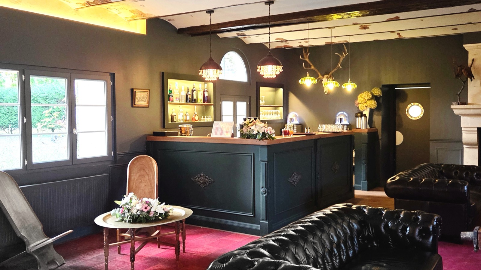 Le bar et les canapés Chesterfield de l'Espace Lounge, au coin de la cheminée de pierre — Le Club des Étangs de l'Abbaye